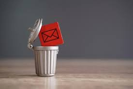 Red email envelope icon being discarded into a trash bin representing spam or deleted emails.